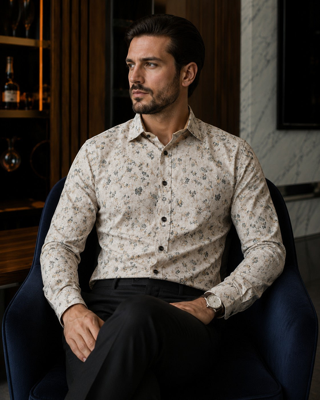 Barutti.ae Casamoda beige cotton shirt with muted floral print and dark buttons worn by a man in a dark armchair