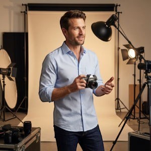 Casamoda blue classic-fit dress shirt worn by a man holding a camera in a professional studio setting