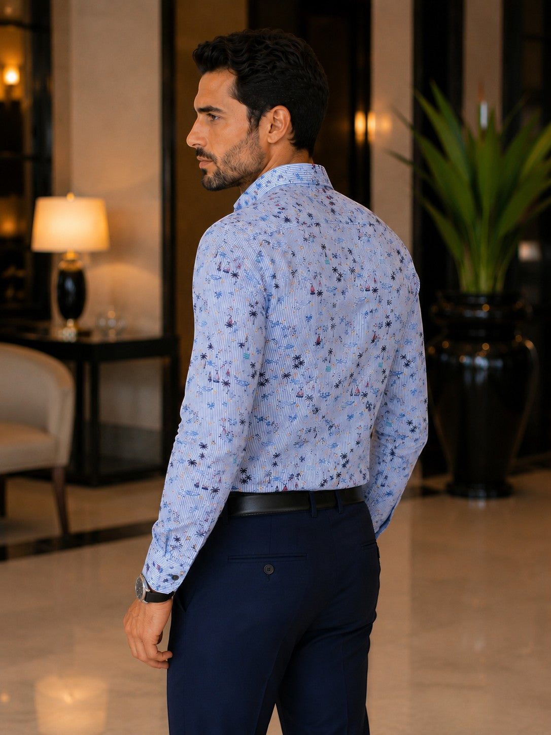 Barutti.ae Casamoda linen-blend shirt with blue pinstripe and nautical palm tree print, worn by a man in a hotel lobby.