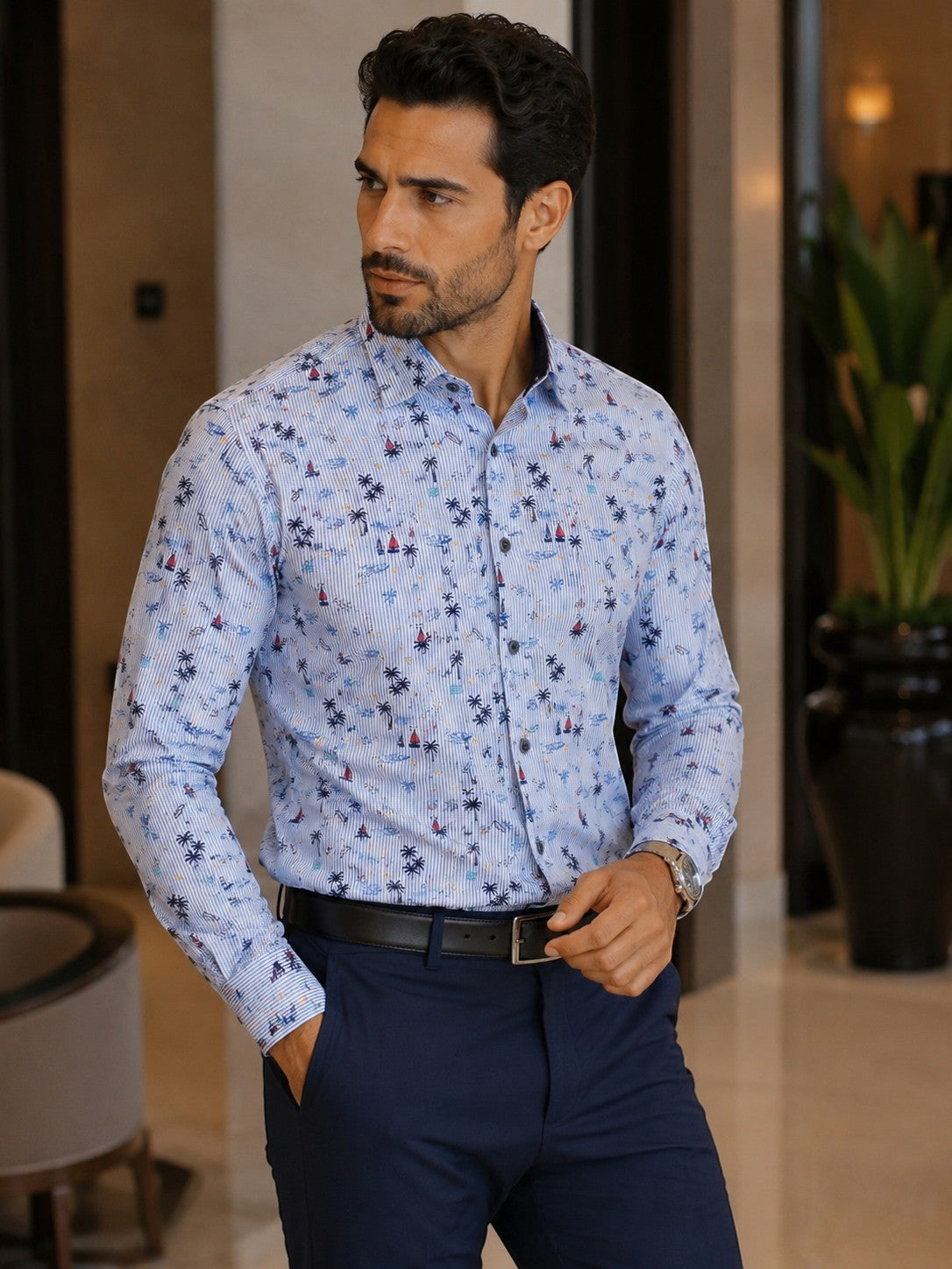 A model wearing a Barutti.ae Casamoda linen-blend shirt with a blue pinstripe and nautical palm tree and sailboat print.