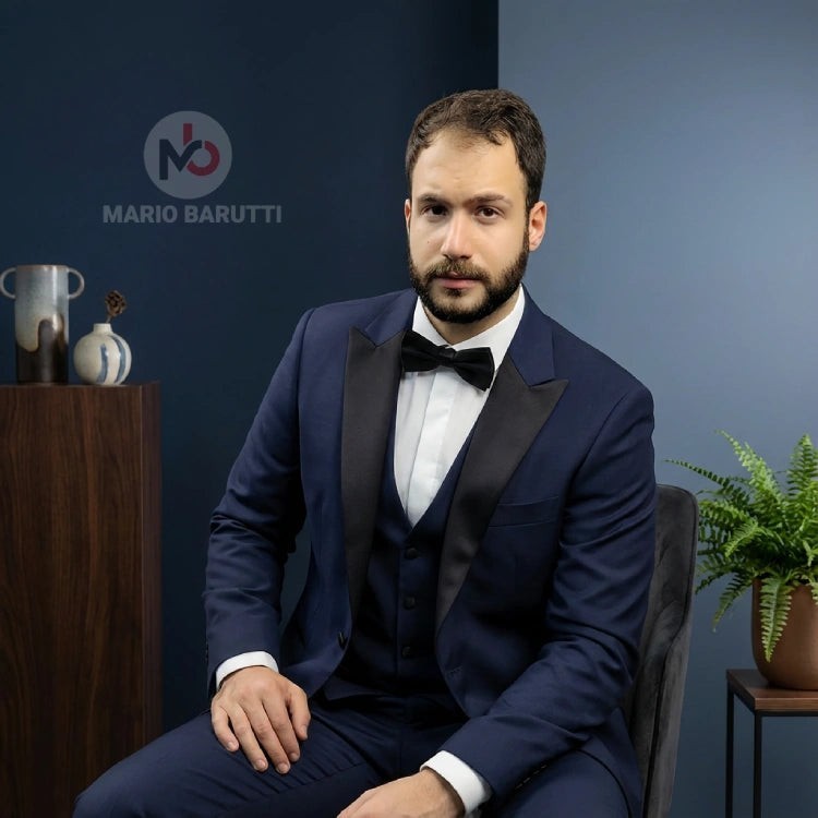 Mario Barutti navy tuxedo with peak lapels and black bowtie worn by a man in a modern studio setting