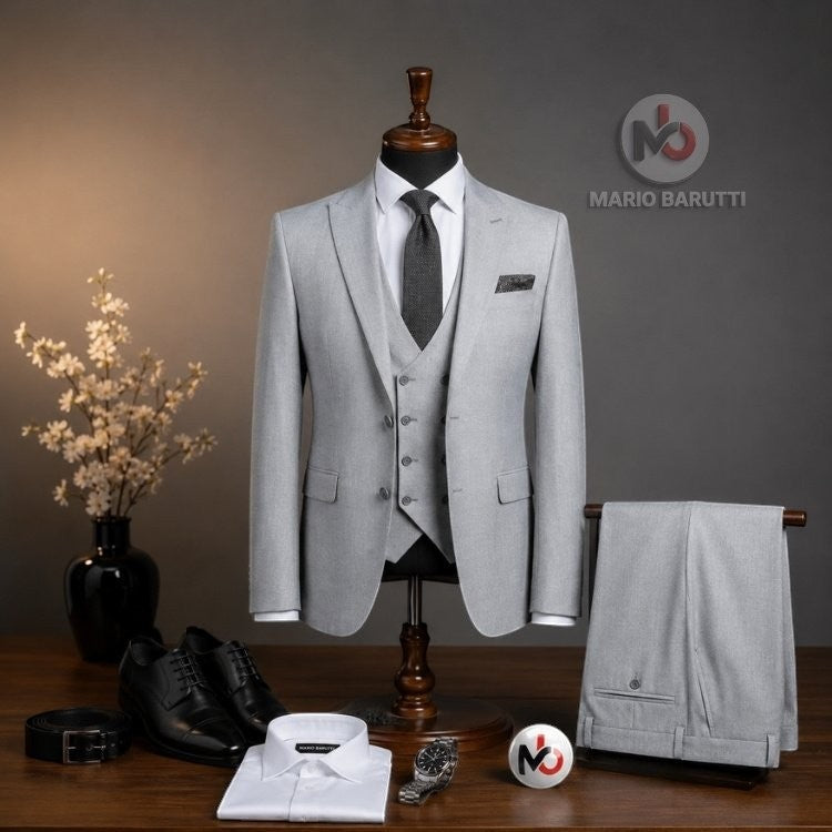 Marco Ricci silver three-piece suit on a mannequin with white shirt, black tie, and matching trousers on a wooden table.