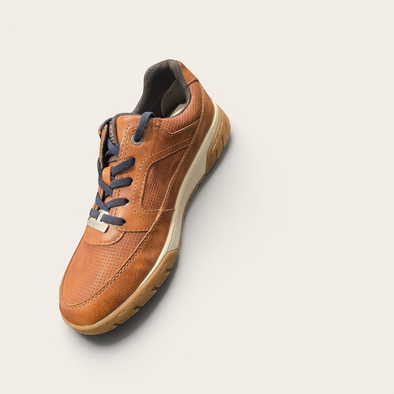 Bugatti tan leather low-top sneakers with perforated texture, lace-up closure, and white midsole.