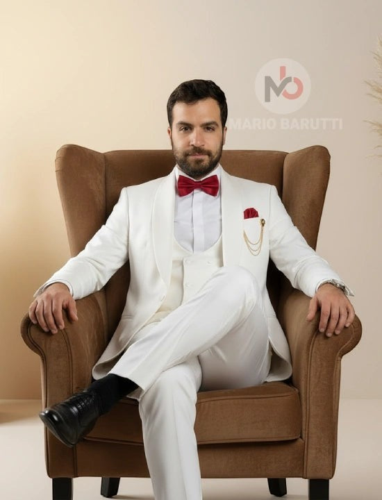 Mario Barutti white tuxedo with shawl lapel, waistcoat, and burgundy bow tie worn by a man sitting in a brown armchair.