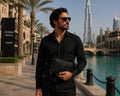 Man in black shirt holding a Barutti Firenze crocodile-embossed leather travel wallet in Dubai