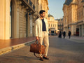 Man holding a Barutti Toscana brown distressed leather weekender duffel on a city street.