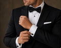 Silver and black rectangular cufflinks worn on a French-cuff tuxedo shirt